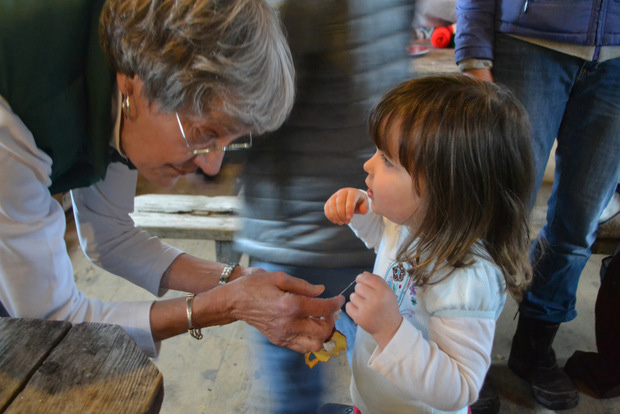 Judy Higbea smiling with a child looking up at her