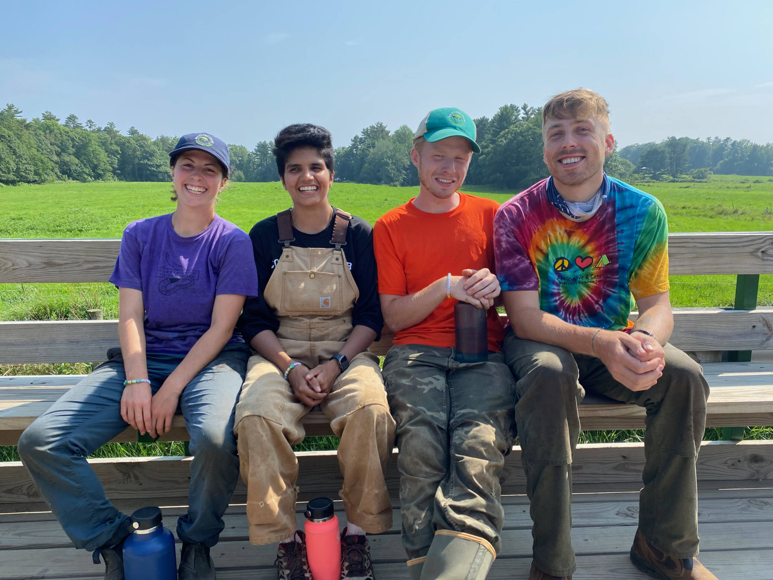 4 farm staffers sitting together in the farm wagon