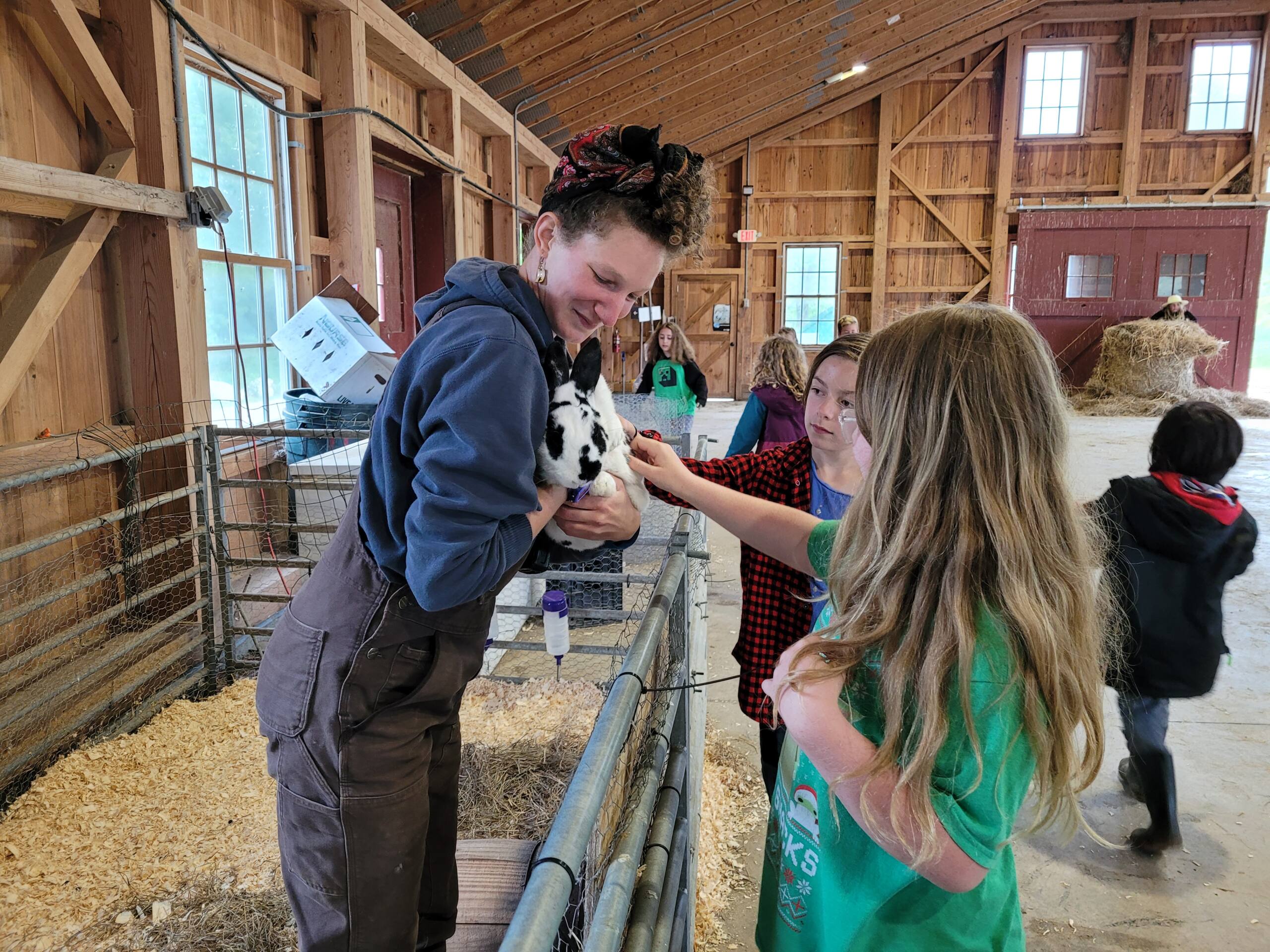 Kids petting a bunny being held by an instructor