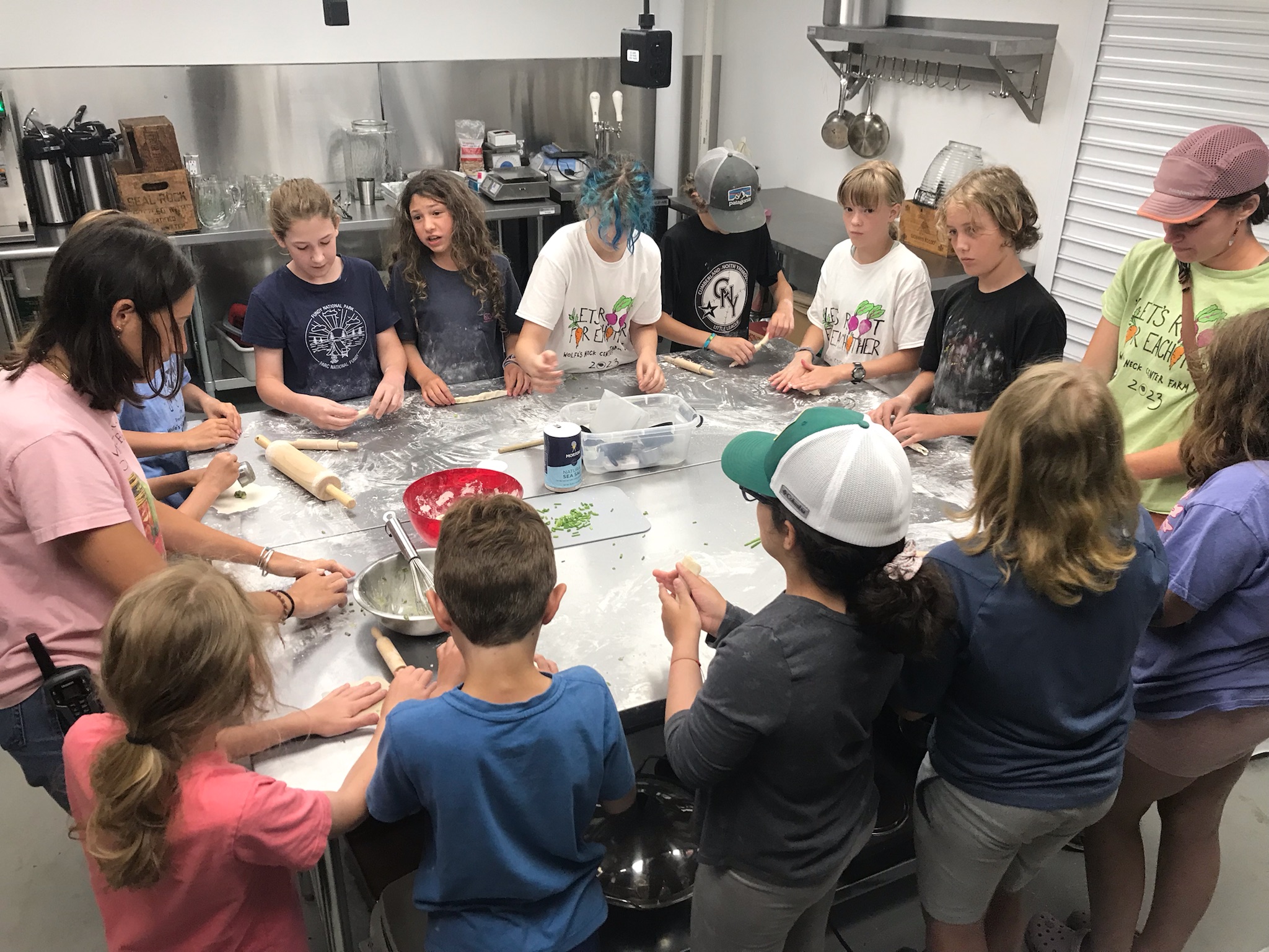 A group of kids around a table learning to cook